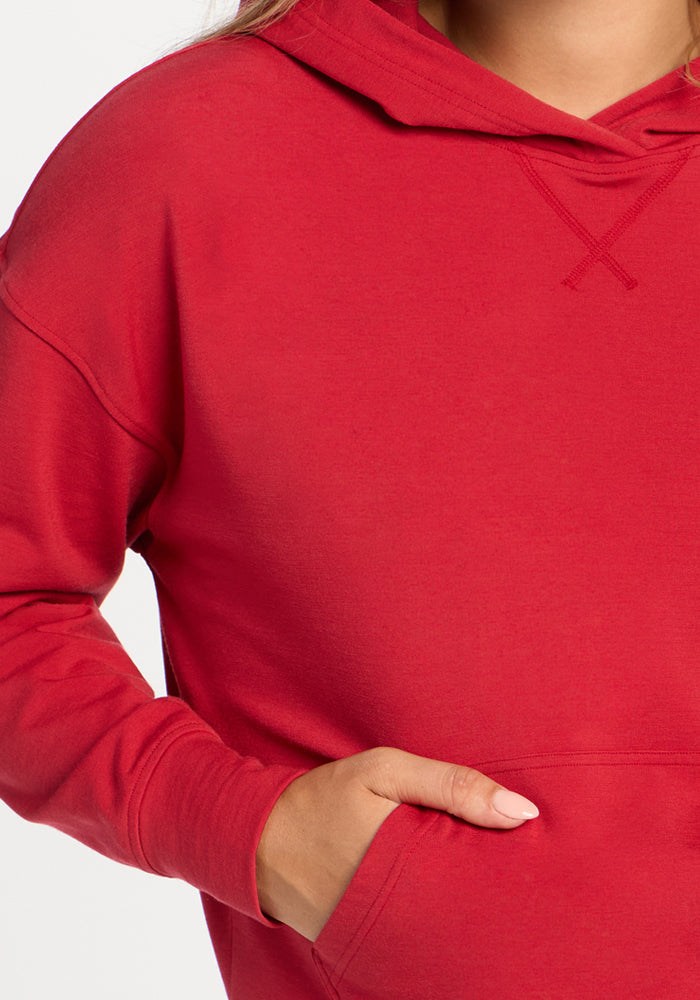 Person in a Woolx Lizzy Hoodie - Maraschino Cherry, hand in pocket, showing light pink manicured nails.