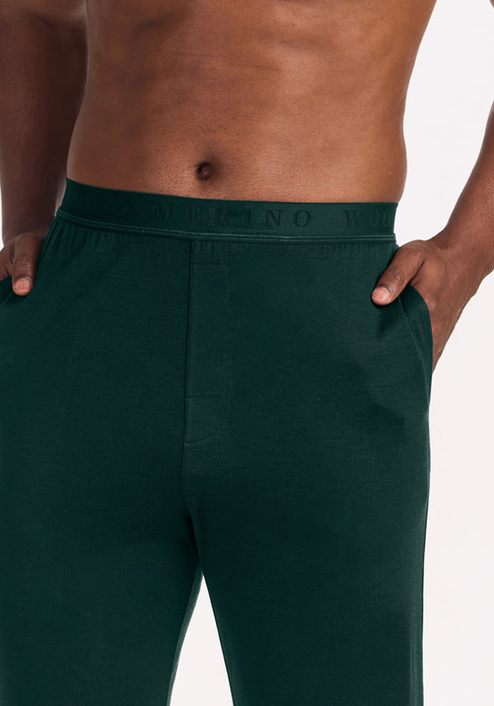 Deep Pine Arlo Lounge Pants with a branded elastic waistband, shown on a person with hands in their pockets.