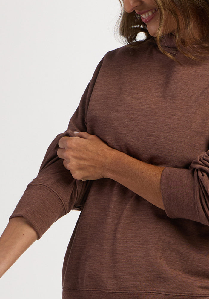 A person wearing a brown Genevieve Hoodie - Sable Heather, adjusting the cuff on their arm.