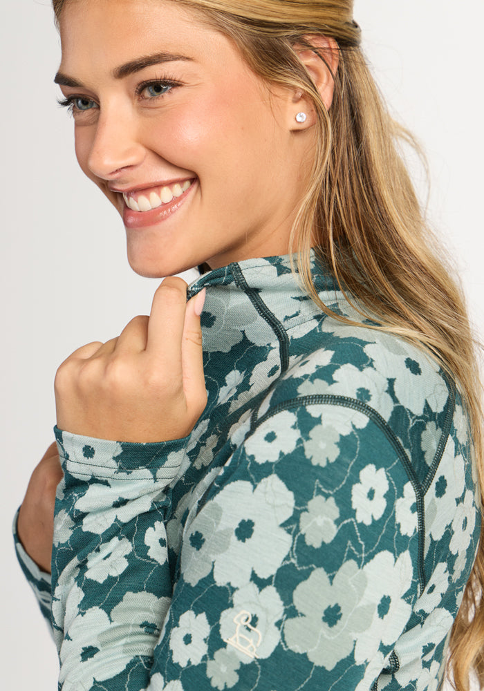 Woman smiling in Woolx Emi 1/4 Zip - Coastal Wildflower, enjoying cozy Merino wool warmth for winter insulation.