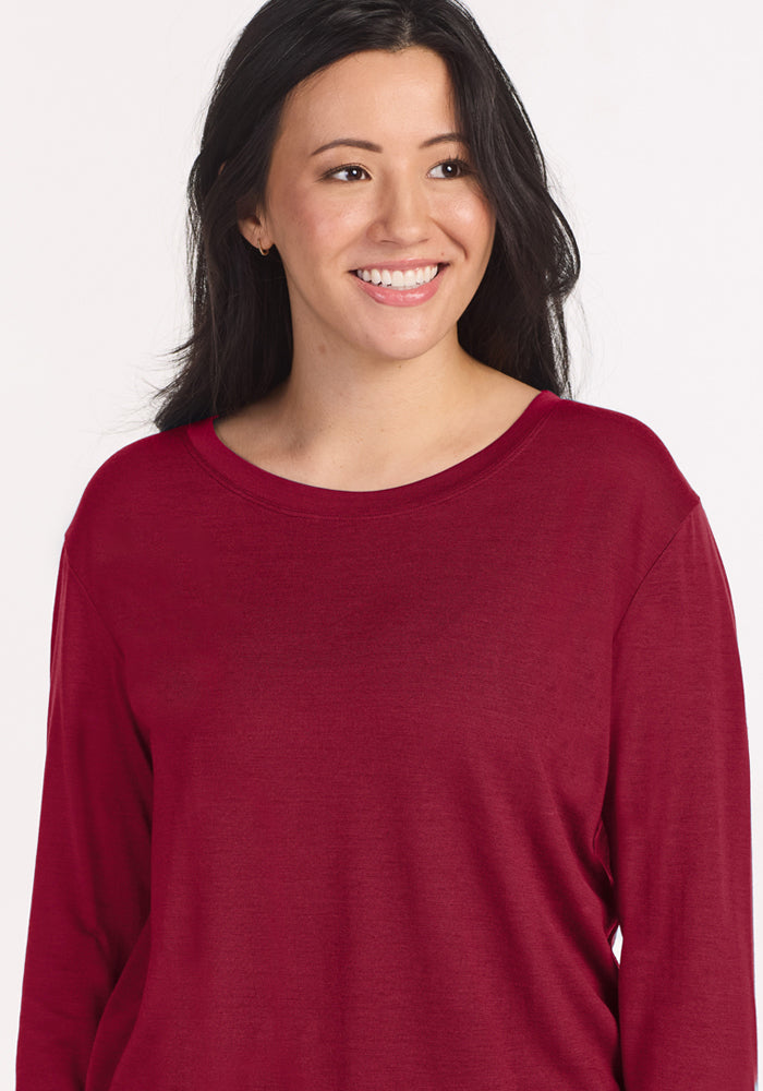 A person wearing a wrinkle-resistant, beet red Woolx Ashlie Lounge Top with a crewneck.