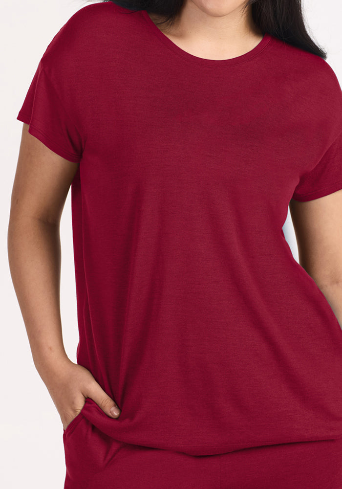 A person wearing a short-sleeved, beet red moisture-wicking Billie Lounge Tee crewneck t-shirt.