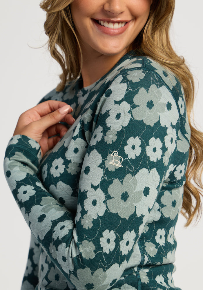 Smiling woman in Woolx Maddie Baselayer Top - Coastal Wildflower, showing small sleeve embroidery detail.