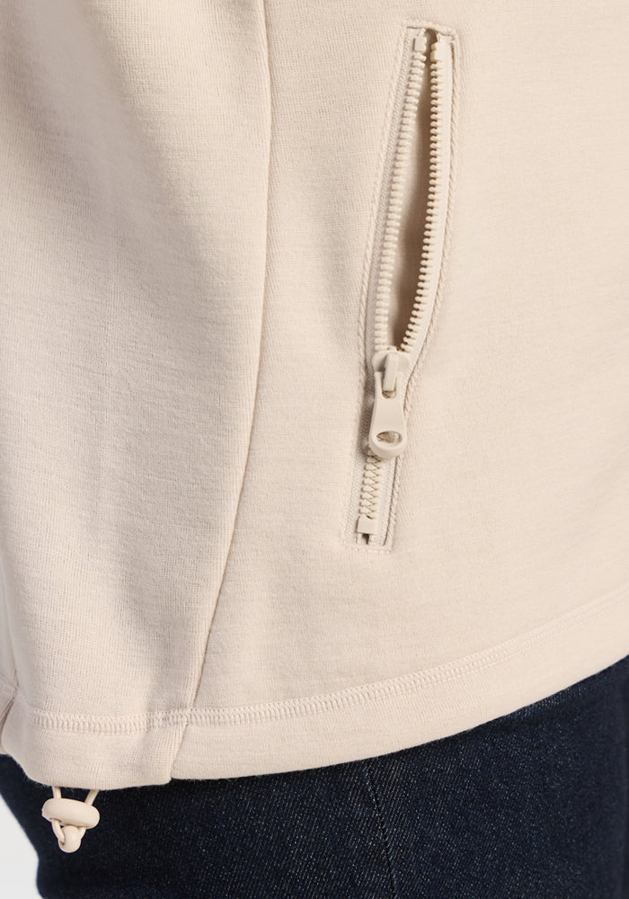 Close-up of an ecru Woolx Teddy Sweatshirt featuring an ultra-heavyweight merino wool fabric, zippered pocket, and hem.