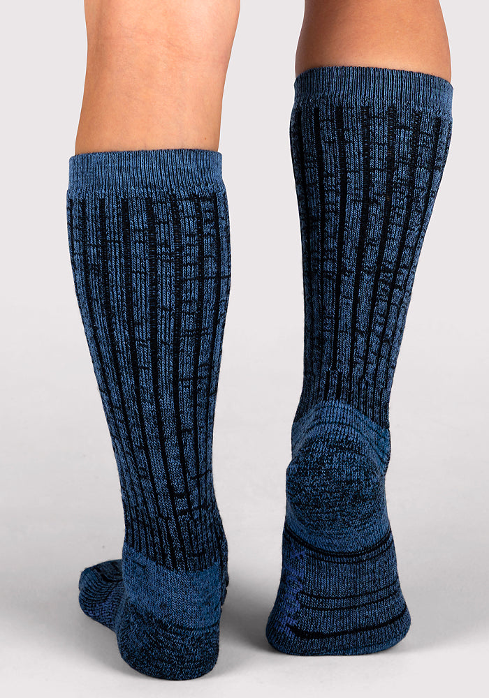 Close-up of a person wearing Woolx Womens Joey Mid Calf Socks in Steel Blue, featuring a ribbed, textured design for comfort and style, standing with feet slightly apart on a neutral background.