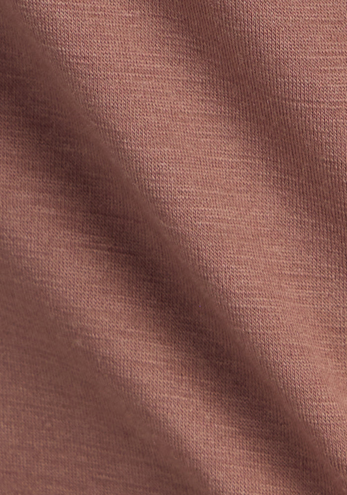 Close-up of the Woolx Bella Tunic Top in Sienna Kiss shows its visible weave and diagonal shadow, highlighting the soft Merino wool texture and subtle folds.