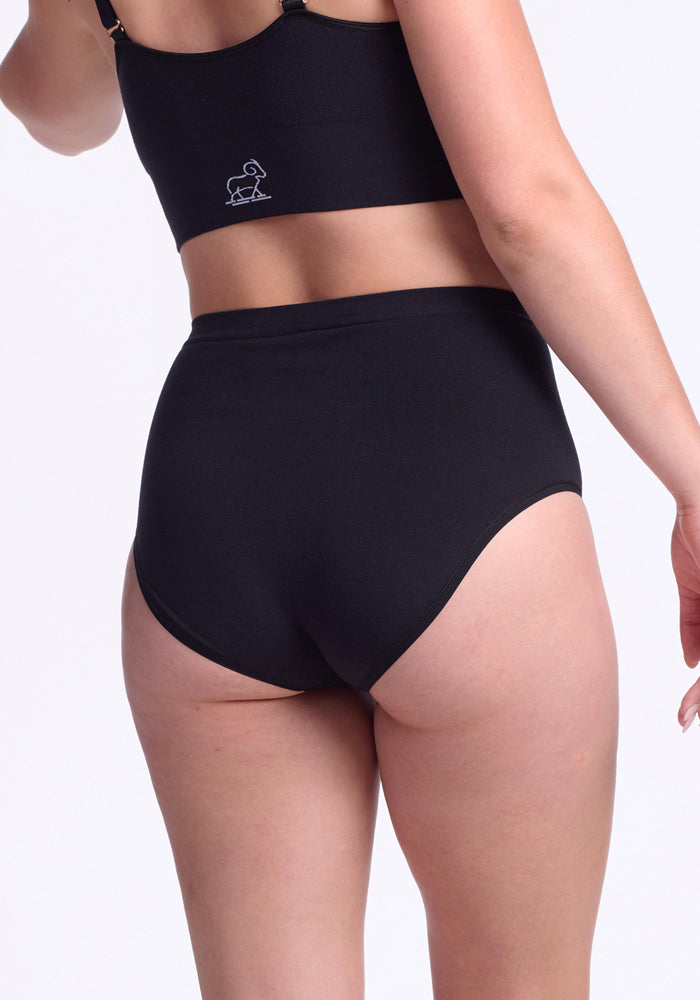Model wears Woolx Mabel Full Coverage Underwear in black with a matching top, shown from the back on a white background, highlighting seamless comfort and full coverage.