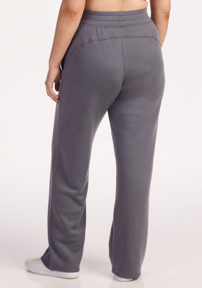 Someone wearing Woolx Bree Lounge Pants in Arctic Dusk stands with their back to the camera, paired with white sneakers against a plain light background.