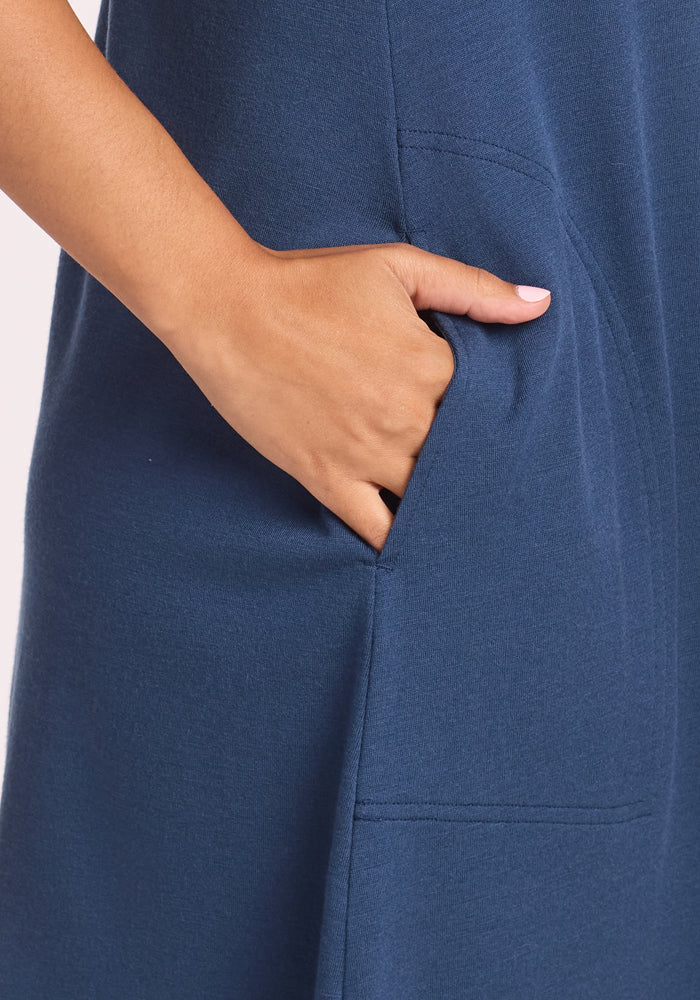 Close-up of a hand in the pocket of the Woolx Clara Dress - Starry Night. Neatly manicured nails complement the soft, breathable, textured fabric for ultimate airy comfort.