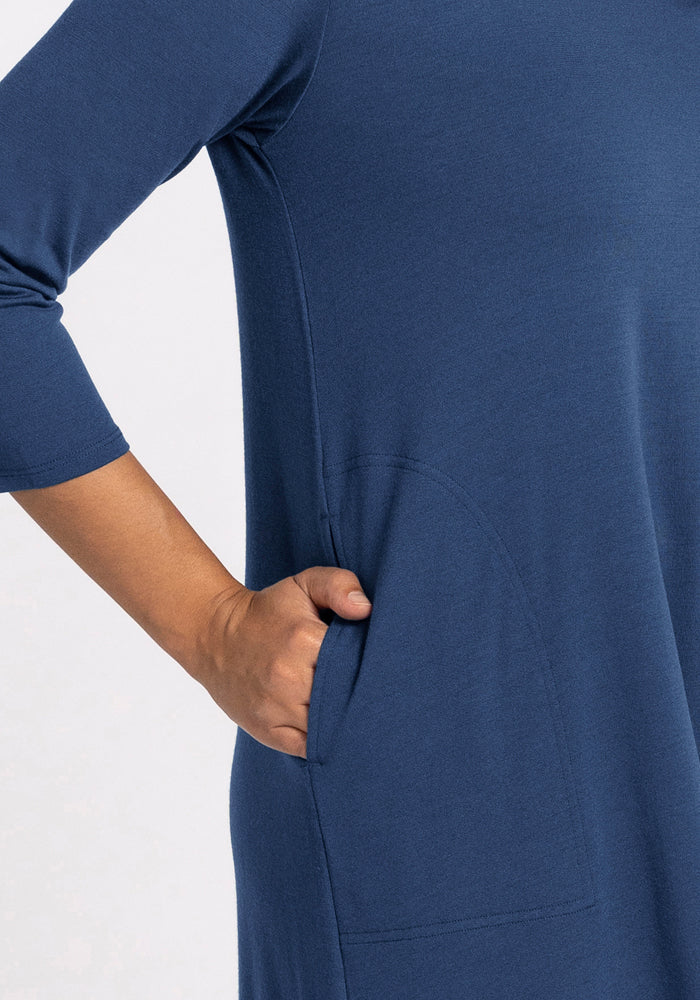 A person wears the Woolx Rissa A Line Dress in Starry Night, their right hand in the side pocket, shown from shoulder to mid-thigh against a plain backdrop—ideal for layering in fall and winter.