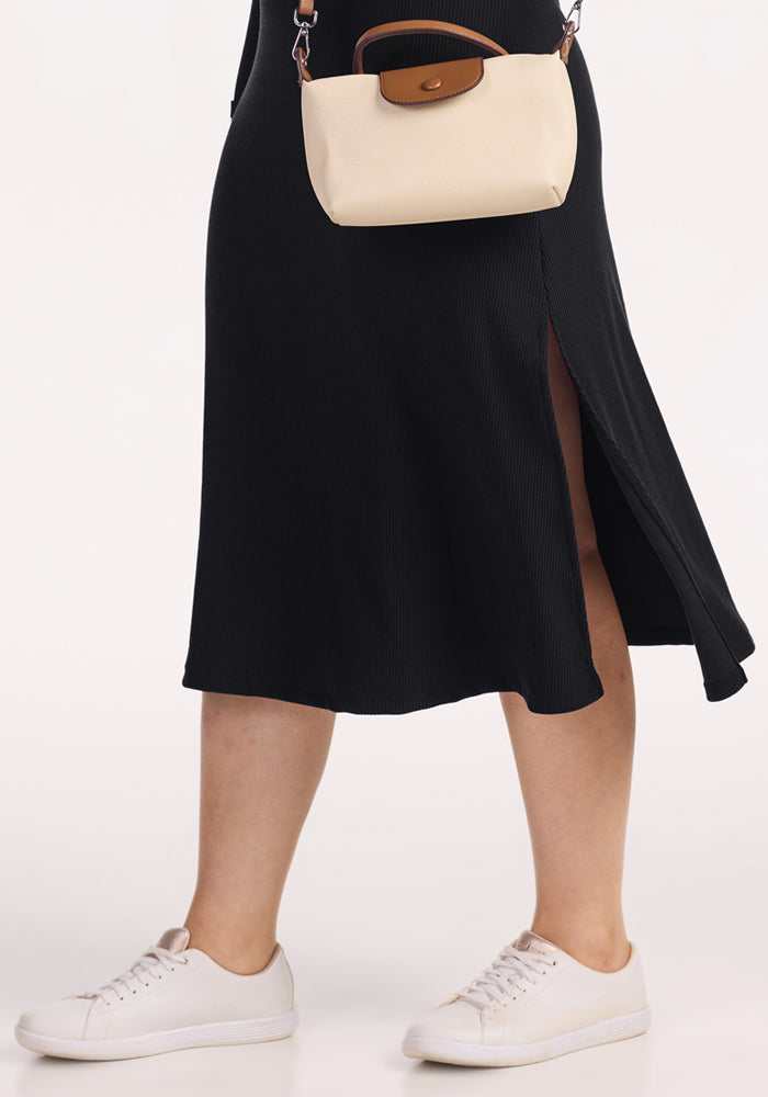 Person in Woolx Caroline Ribbed Twirl Dress - Black, white sneakers, and a small cream crossbody bag.