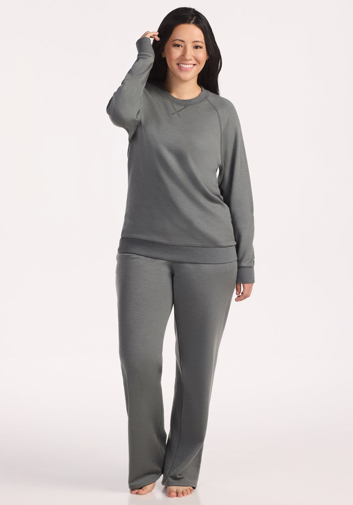 A woman in a Woolx Bailey Crewneck Sweatshirt in Sedona Sage and a matching tracksuit.
