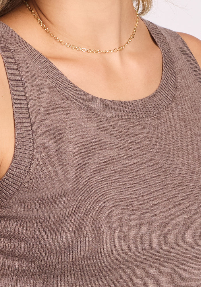 A close-up of a person wearing the Woolx Chessy Tank Top in Simply Taupe, styled with a delicate gold chain necklace. Only the shoulders, neck, and upper chest are visible—ideal as a layering piece.