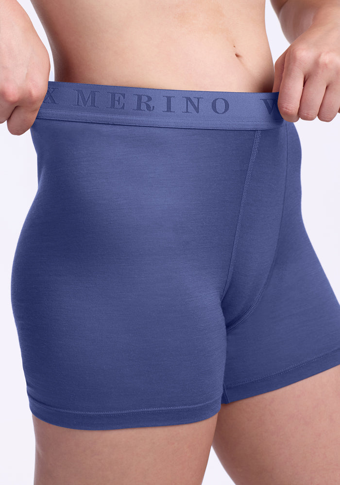 A person wearing Woolx Elliott Boyshort - Cloudy Bay underwear is shown adjusting the waistband, with focus on the midsection and upper thigh area.