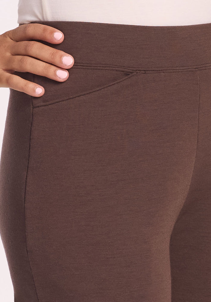 A close-up of a person wearing Woolx’s Ellie Wide Leg Pants Petite in Bracken and a white top, highlighting the waist and pocket area—an ideal choice for petite women seeking effortless style.