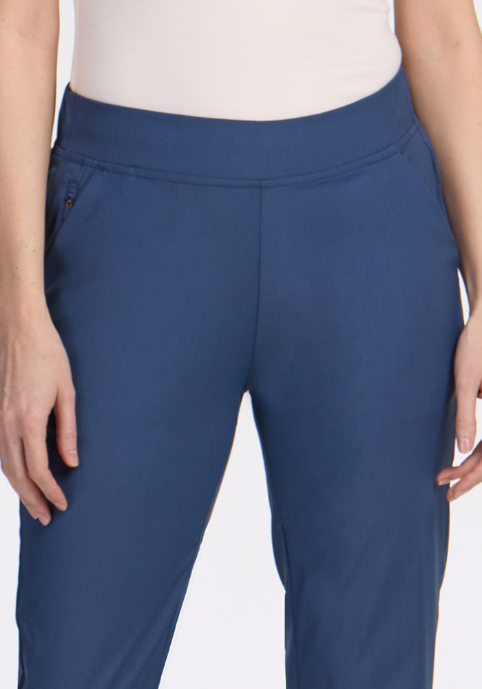 A person models the Woolx Nicole Ankle Pants in Vintage Indigo, shown from waist to mid-thigh, paired with a white top, standing with hands relaxed at their sides.