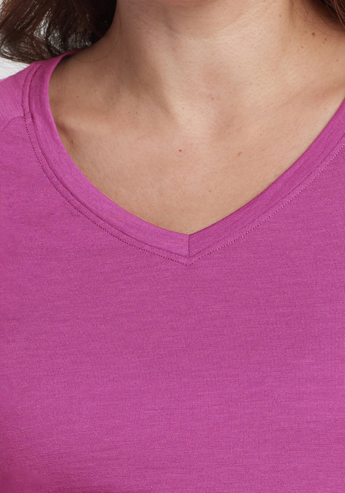 Close-up of a person wearing the Woolx Mia V Neck in Purple Wine, highlighting the Merino wool fabric and V-neckline. The background and face are not shown.