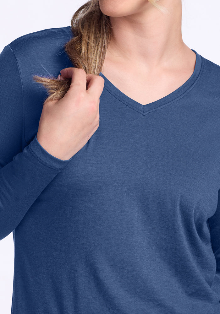 A person wearing the Woolx Millie Long Sleeve in Starry Night is holding a section of their light brown hair with their right hand, and their face is partially out of frame.