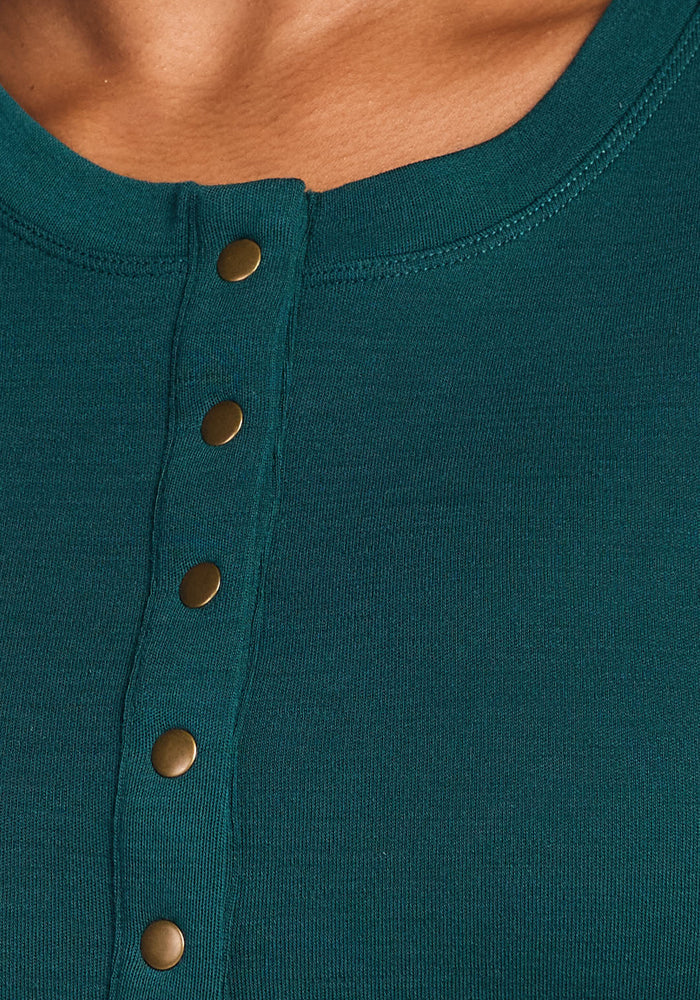 Close-up of the Woolx Charlotte Puff Sleeve Top in Riverbank Green, featuring Henley-style buttons and a round neckline. The soft, smooth fabric and part of a person's neck and shoulder are visible.