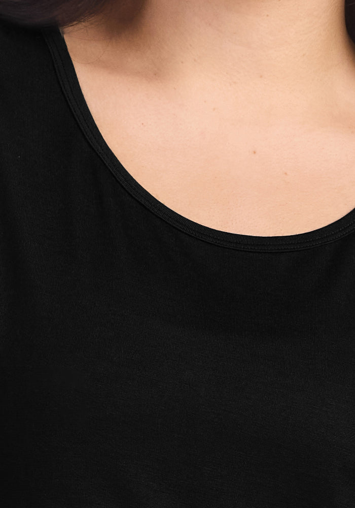 Close-up of a person wearing the Woolx Lucille Long Sleeve Nightgown in black, highlighting the neckline and upper chest. The person's light skin tone is visible; no other clothing or accessories are shown.