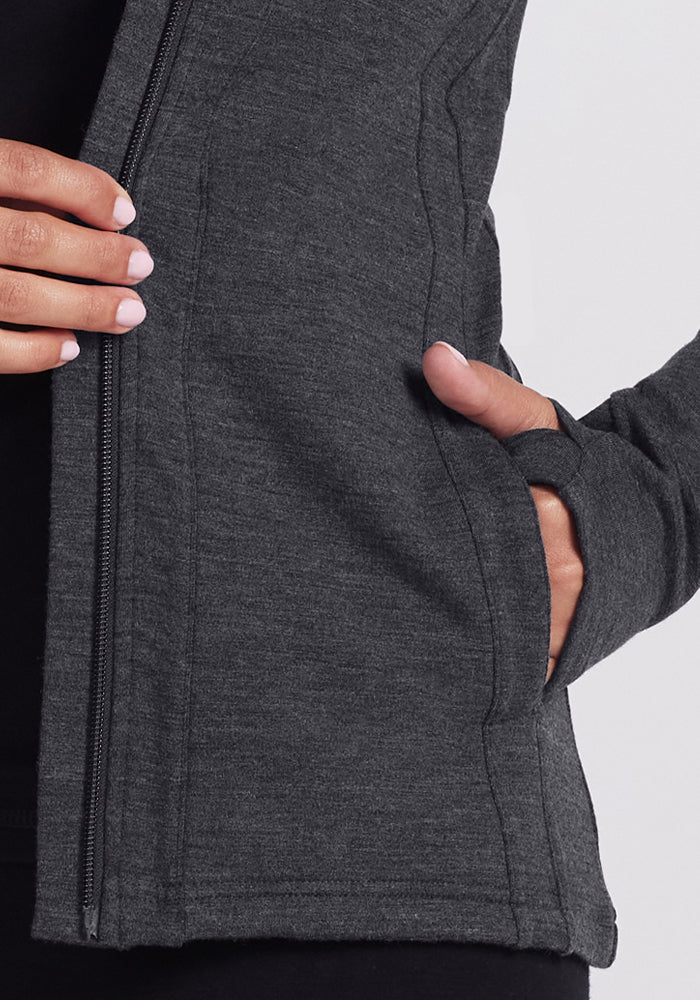 A person wearing a Woolx Zoey Zip Up Hoodie in Cinder Melange.