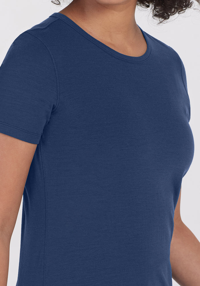 A person wearing the Woolx Liza Crew Neck Tee in Starry Night, a fitted short-sleeve Merino wool t-shirt, shown from chest to neck with their face partially out of frame.