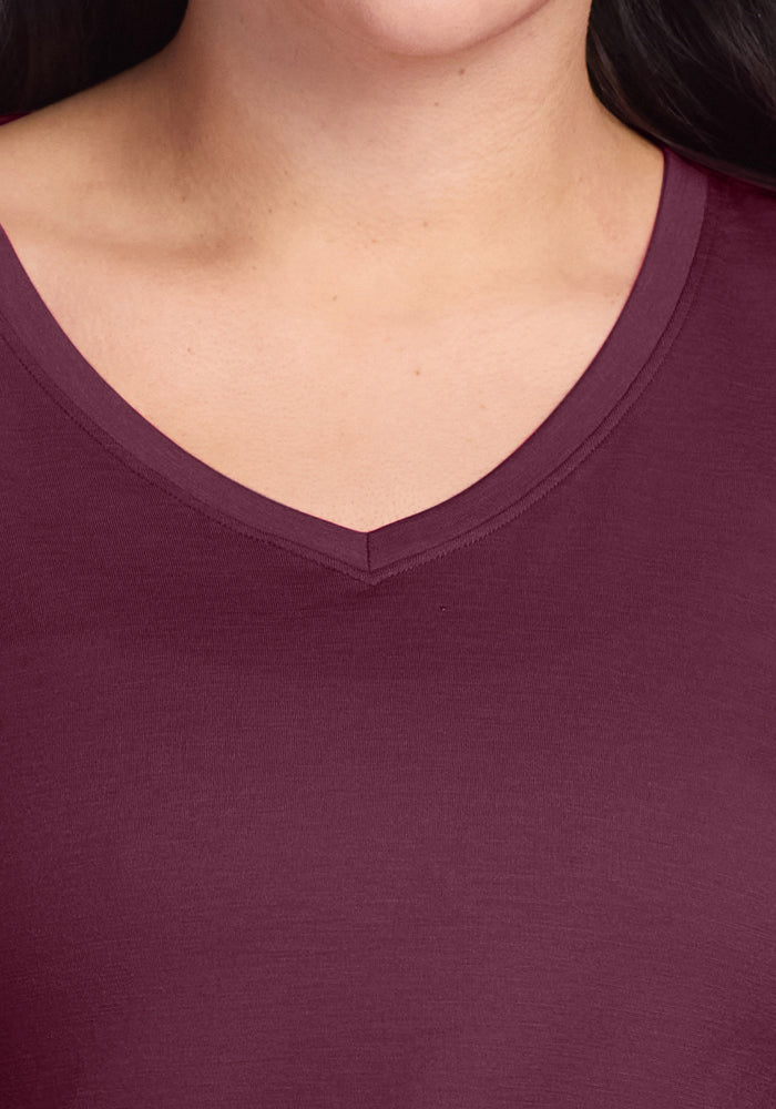 Close-up of a person wearing the Woolx Millie Long Sleeve in Grape Harvest, highlighting the V-neckline, upper chest, neck, and chin with dark hair partially visible.