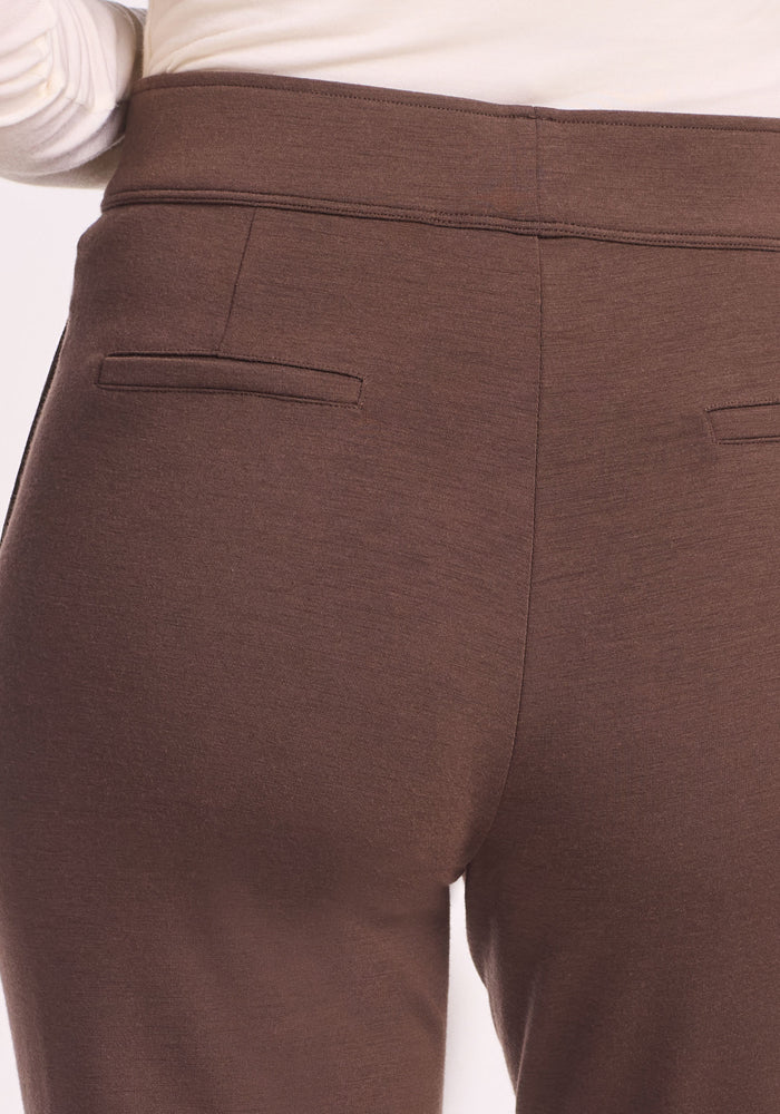 Close-up of the back of a person wearing Woolx Emerson Straight Leg Pants Petite in Bracken with two small welt pockets and a white top, showcasing the pants’ moisture-wicking Merino wool fabric.