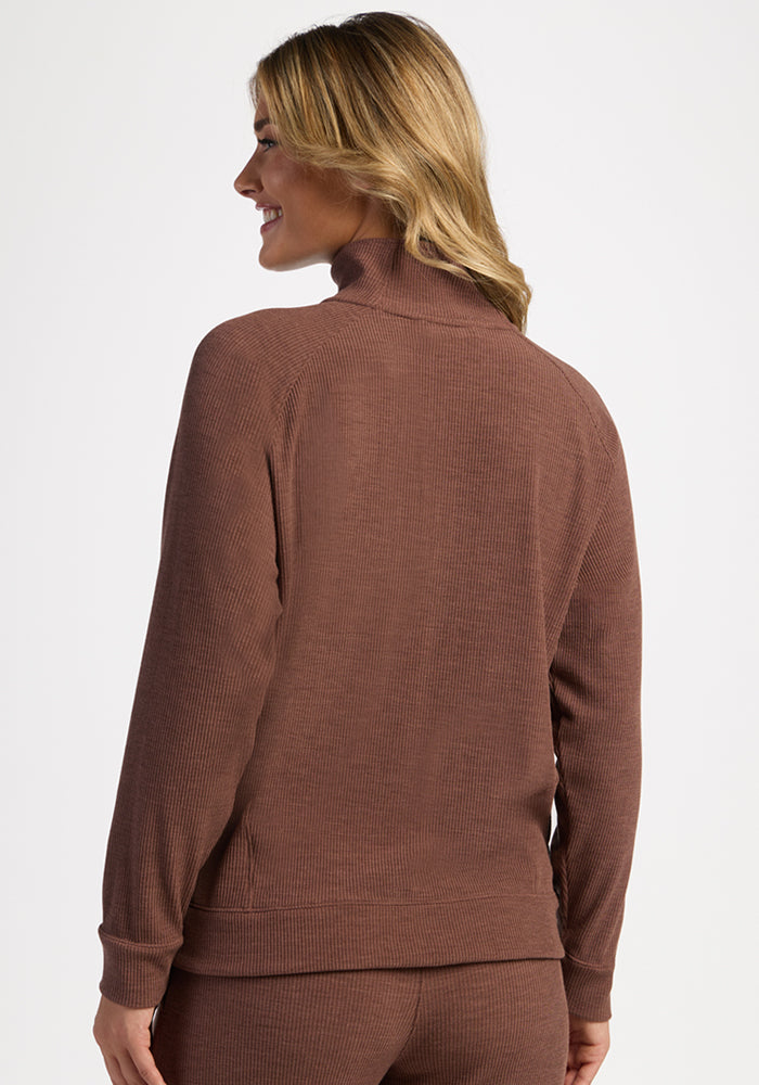Woman wearing Woolx Quinn Ribbed 1/4 Zip in Sable Heather, shown from the back, smiling and looking left.