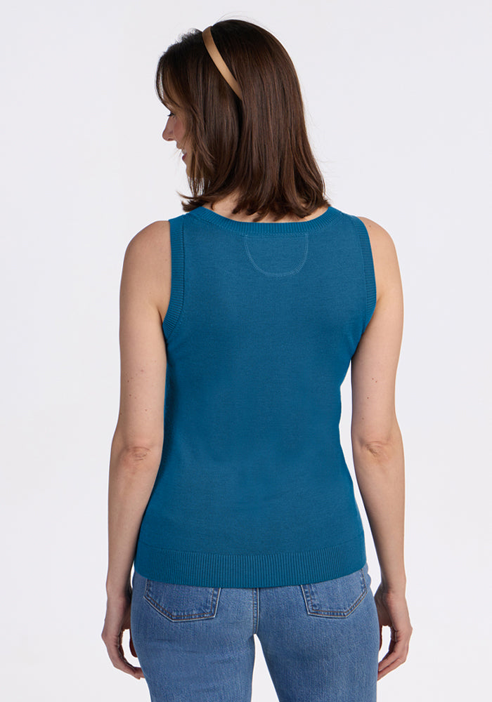 Woman in Woolx Chessy Tank Top - Blue Pine and jeans stands with her back to the camera against a plain background.
