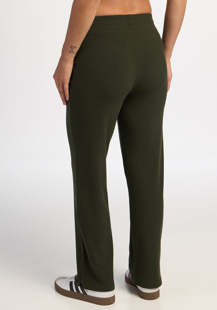Model wears Woolx Luca Ribbed Pants - Duffel Bag with white sneakers, shown from the back against a plain background.