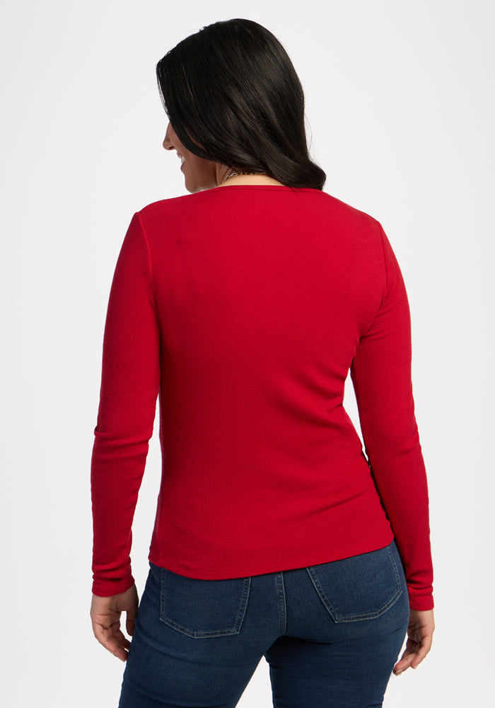 Woman with long dark hair wears the Woolx Katie Ribbed Long Sleeve in Maraschino Cherry, facing away from camera.