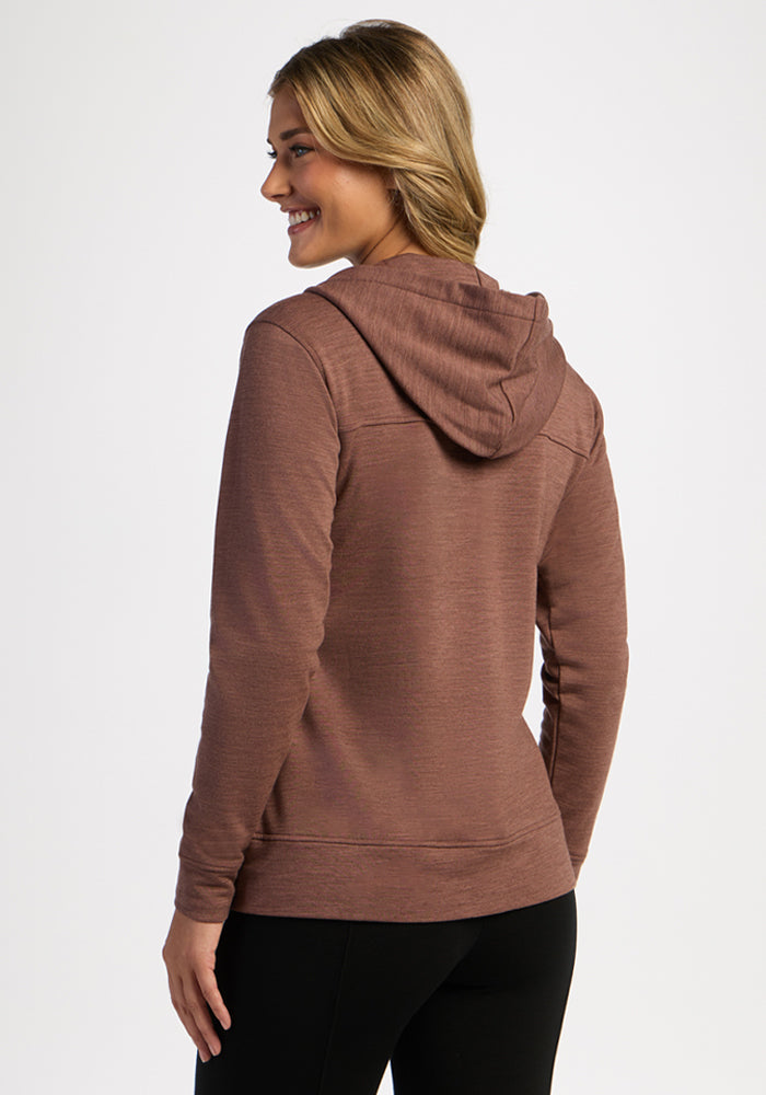 Woman smiling in the Woolx Darby Zip Up Hoodie - Sable Heather, facing away with hands by her sides.