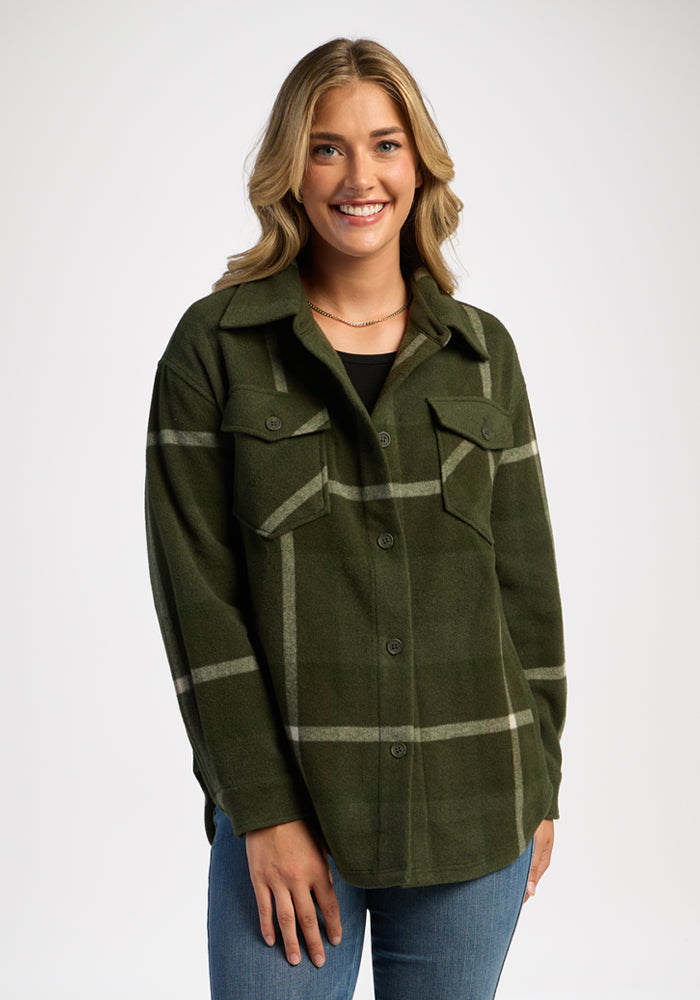 Confident woman in Woolx Sawyer Shacket - Driftwood Fern Plaid and jeans stands against a plain white background. | Ariana is 5'11", wearing a size S