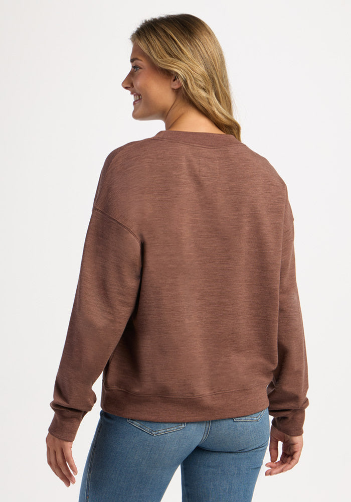 A woman seen from the back wearing a brown Molly Crewneck - Sable Heather and blue jeans.