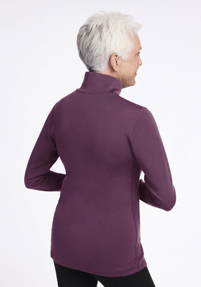 Older woman in a Woolx Brooke 1/4 Zip - Purple Iris stands with her back to the camera.