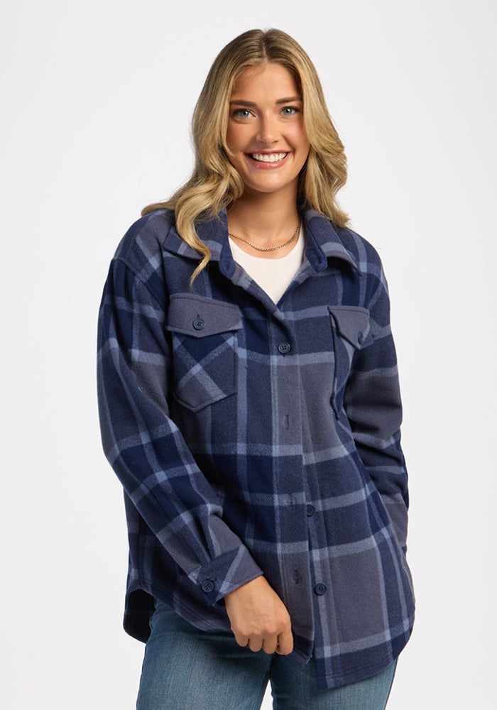 Confident woman in Woolx Sawyer Shacket - Midnight Harbor Plaid and jeans, standing against a plain white background. | Ariana is 5'11", wearing a size S