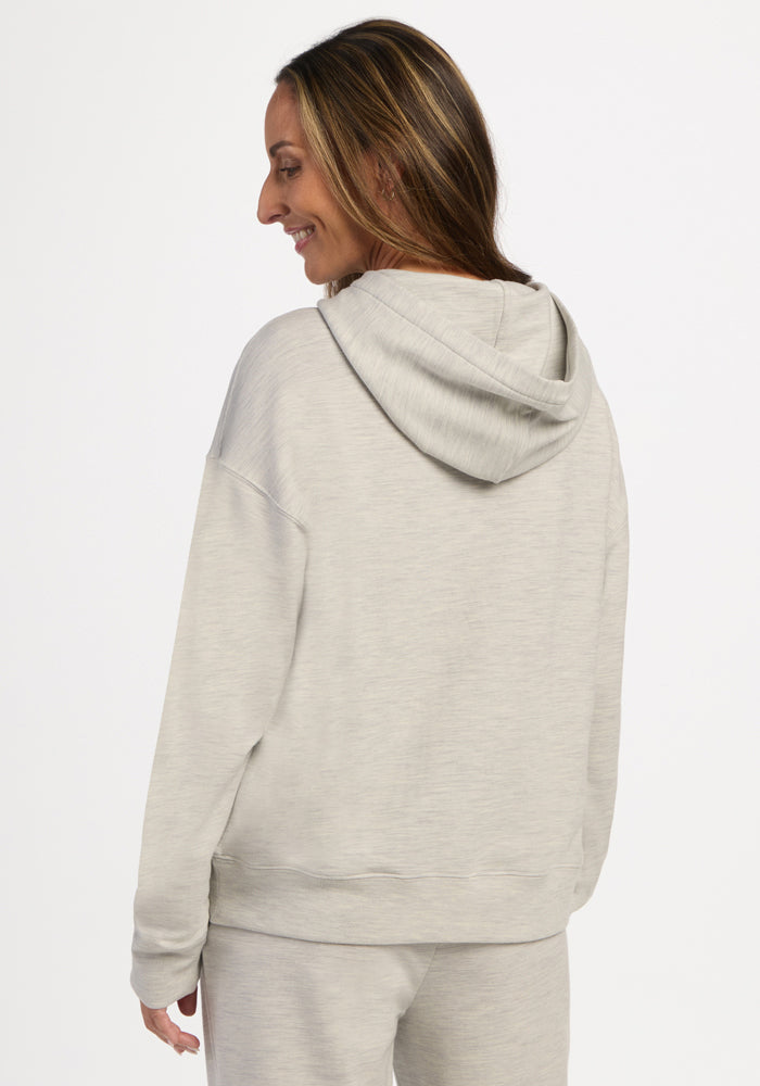 A person seen from behind wearing a light ash Genevieve Hoodie, a light gray temperature-regulating hoodie.