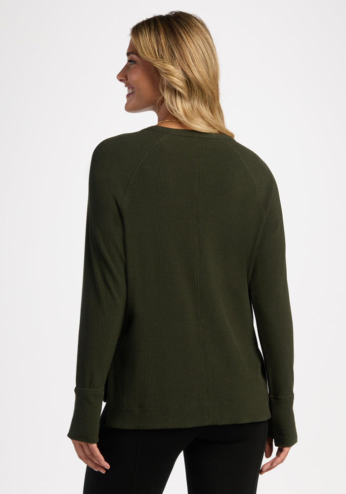 Blonde woman, back to camera, wears Woolx Ainsley Petite Sweater in Duffel Bag and black pants.