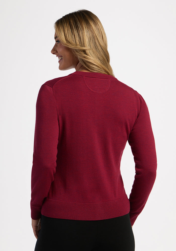 Woman with long blonde hair in Woolx’s Caitlin Sweater - Beet Red, facing away and smiling over her shoulder.
