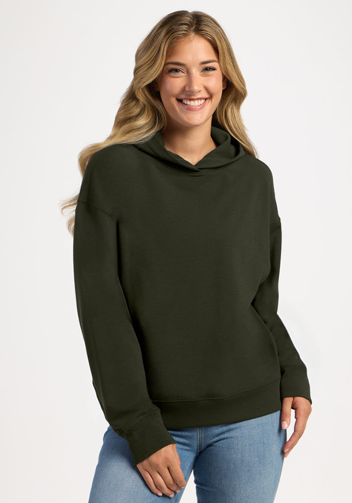 A smiling woman wearing a dark green merino wool Genevieve Hoodie - Duffel Bag. 