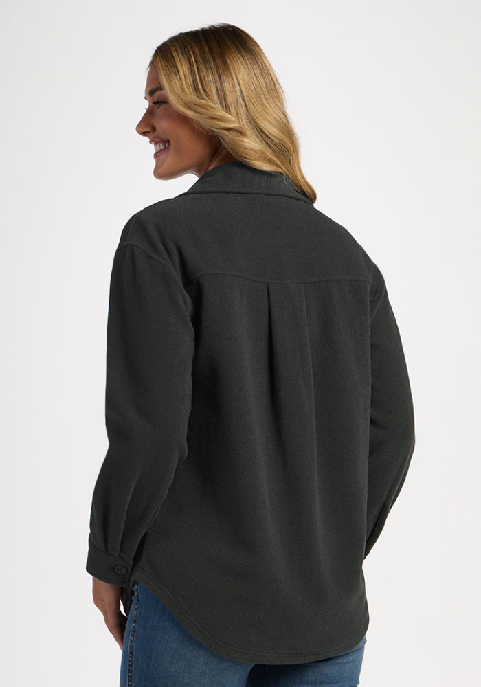 Smiling woman in the Woolx Jovie Shacket - Volcanic Ash, shown from the back—an ideal warm layering piece.