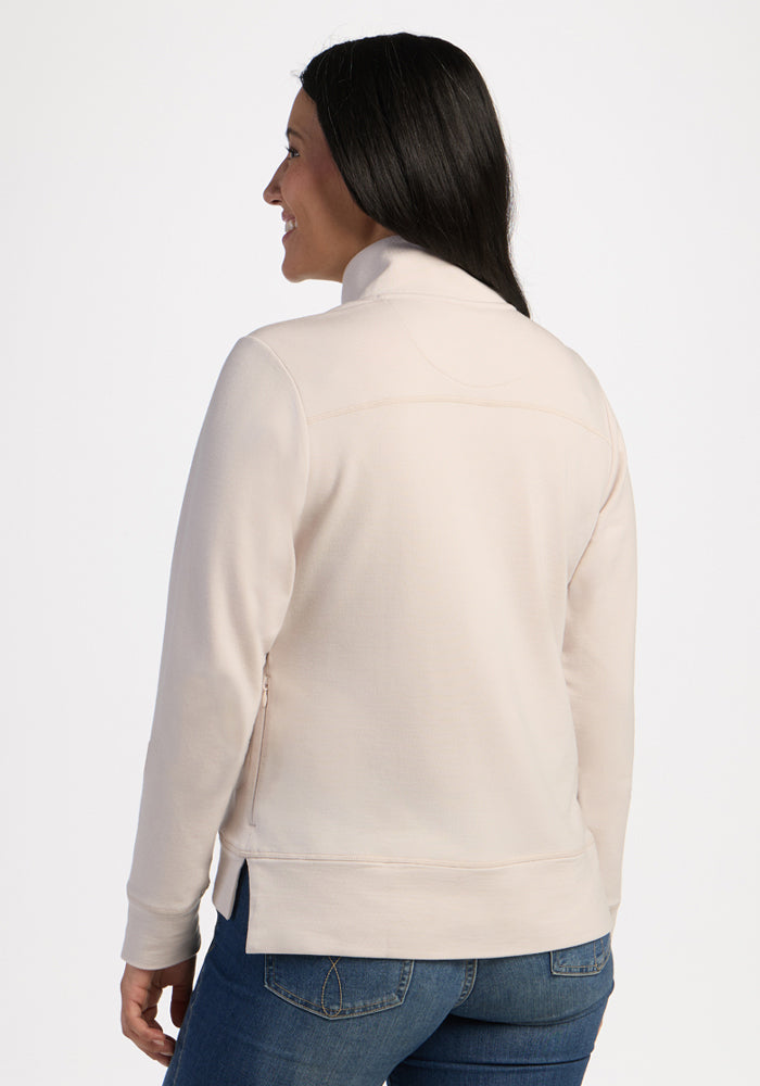 Woman with long dark hair in jeans and the Woolx Annie 3 Button Pullover - Ecru smiles, facing away on white.