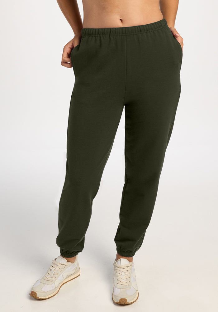 Model in Woolx Juliette Joggers - Duffel Bag, hands in pockets, paired with white sneakers against a plain backdrop. 