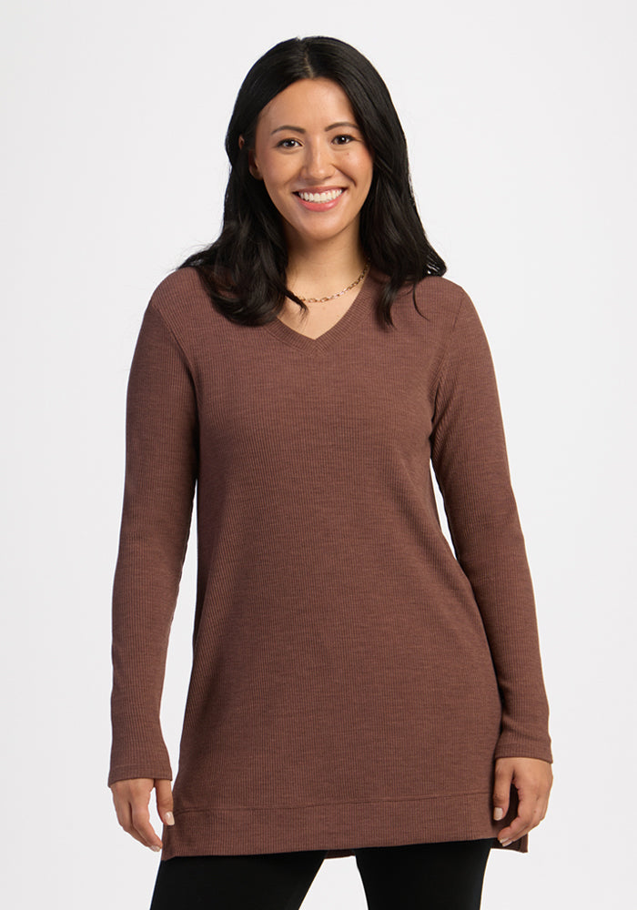 Smiling woman wears Woolx Evie Ribbed Tunic in Sable Heather with black pants, standing against a white background. 