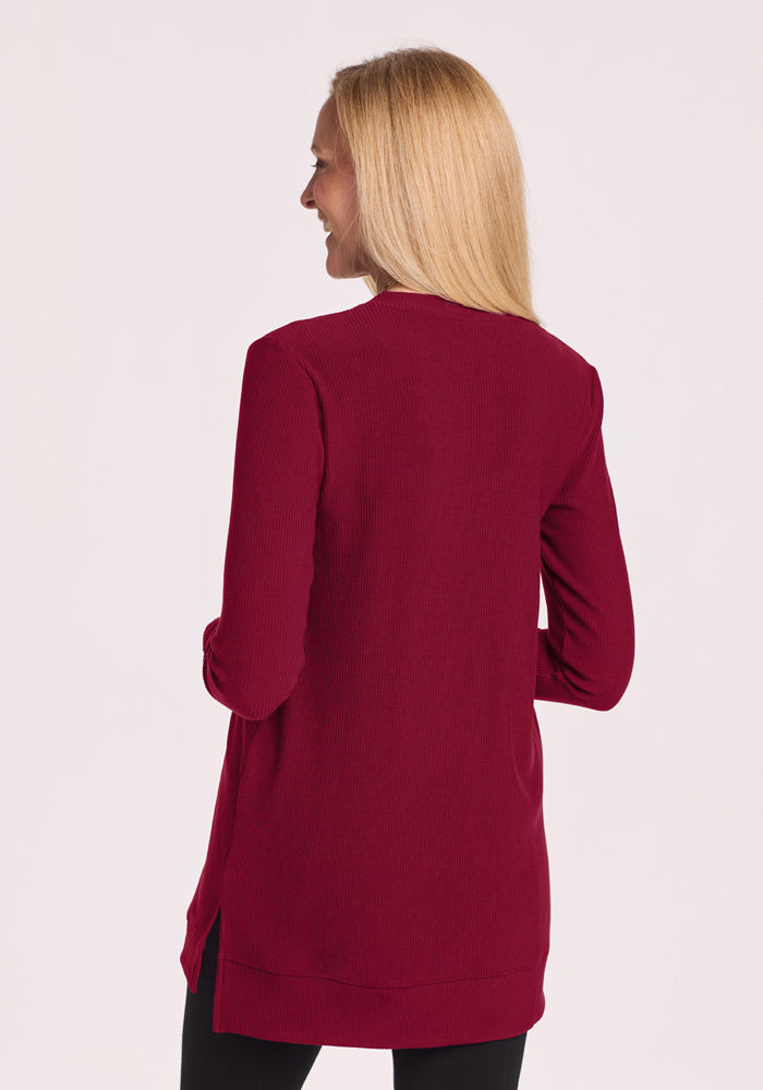 Woman in Beet Red Evie Ribbed Tunic by Woolx, long blonde hair, shown from the back against a plain background.