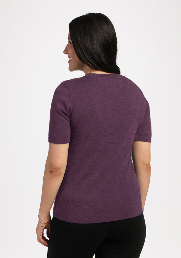 Woman with long dark hair wearing the Woolx Anna Crew Sweater in Purple Iris, back to camera, white background.