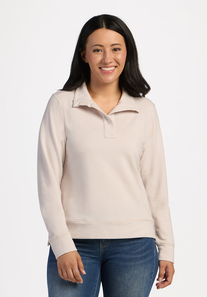 Smiling woman in Woolx Annie 3 Button Pullover - Ecru and blue jeans stands against a white background. 