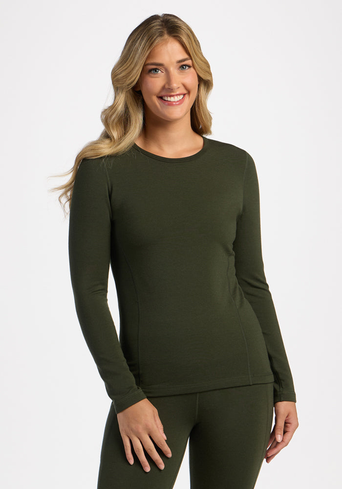 Woman with long blonde hair wearing the Woolx Elsa Long Sleeve - Duffel Bag, smiling warmly at the camera. 