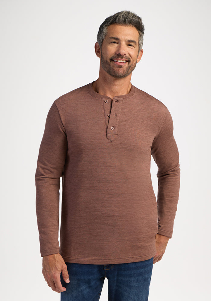 Man with short gray hair wears the Woolx Jackson Henley - Sable Heather and blue jeans, smiling at the camera. 